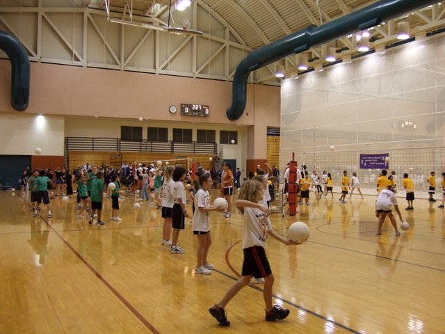 Kids playing volleyball in a gymnasium